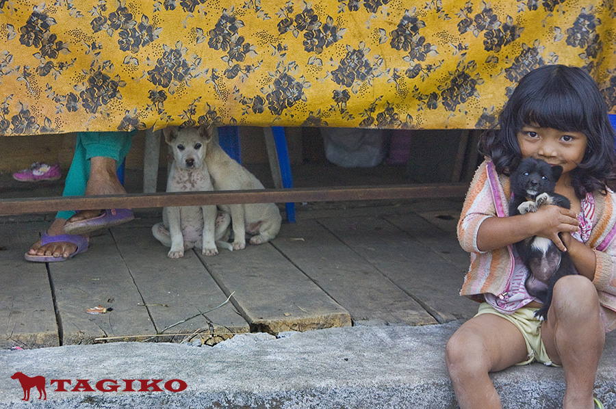 Bambina-e-cucciolo-sotto-tavolo-Bali
